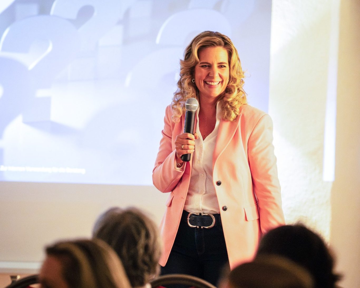 Natascha Enders hält eine Keynote zu Female Finance auf einer Bühne, Mikrofon in der Hand.